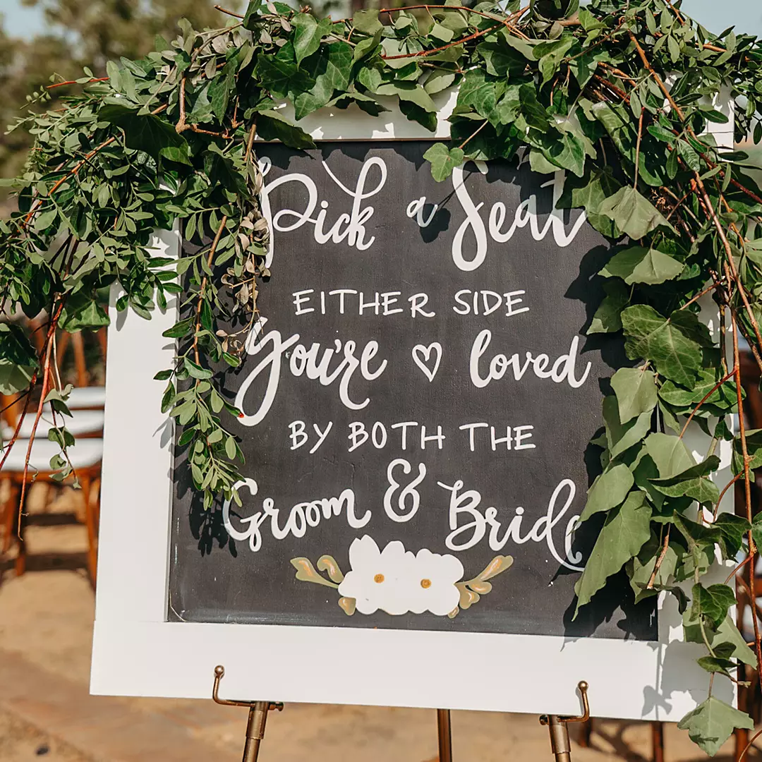 A chalkboard wedding sign reads, 